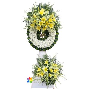 White orchid wreath mixed with yellow lilies